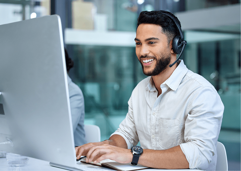 Smiling professional using computer and headset