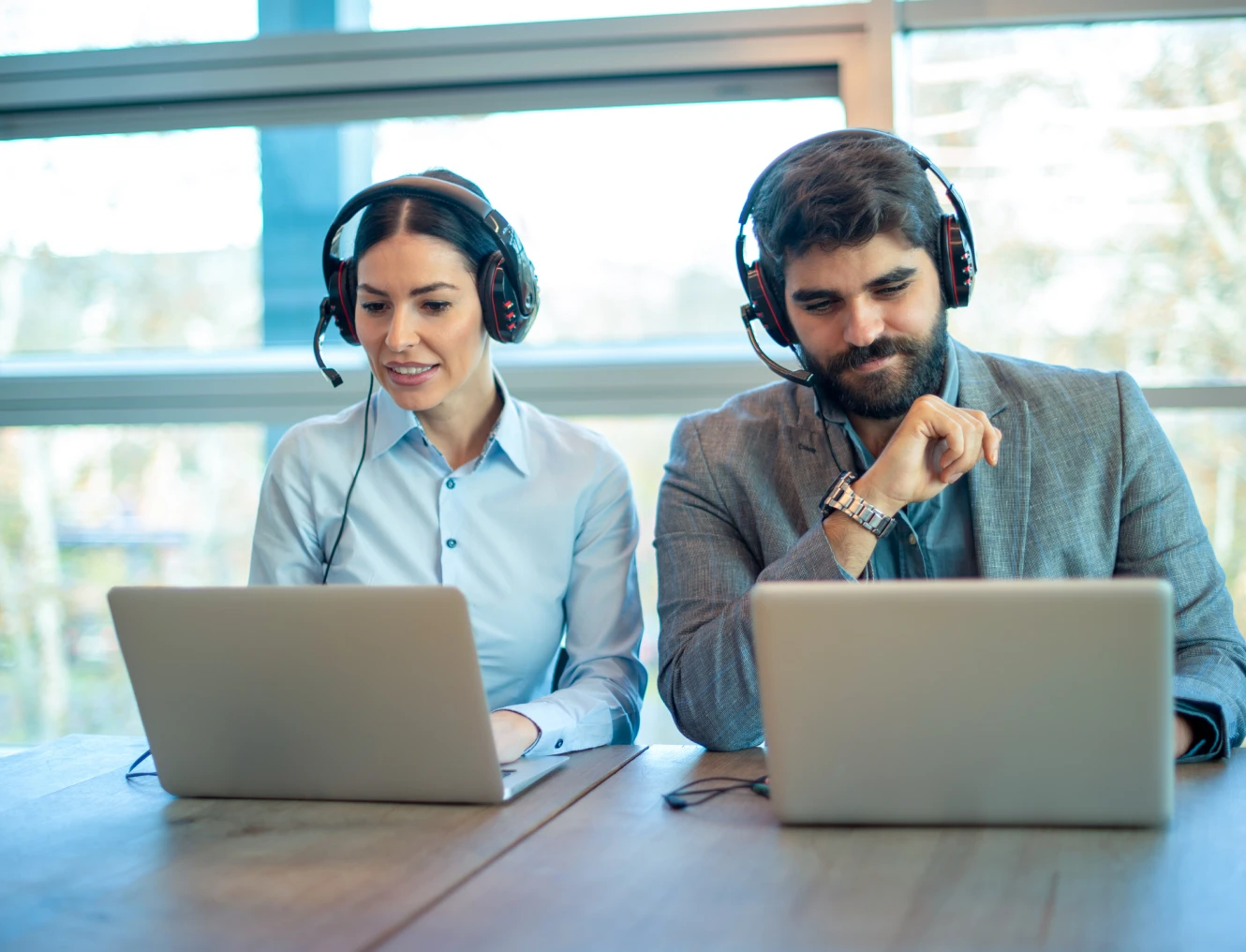 Colleagues working on laptops with headsets