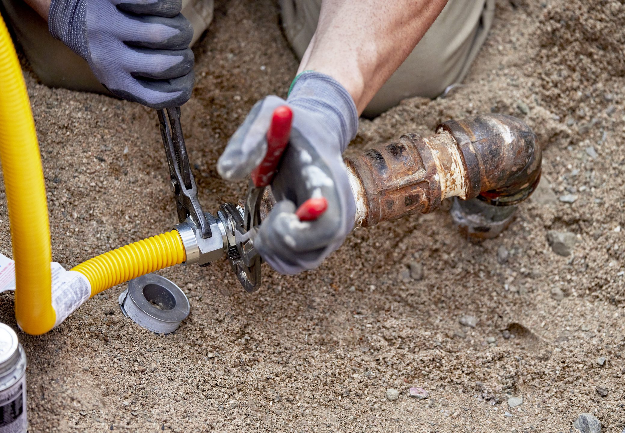 A Plumber hooking up a temporary gas line to a propane tank