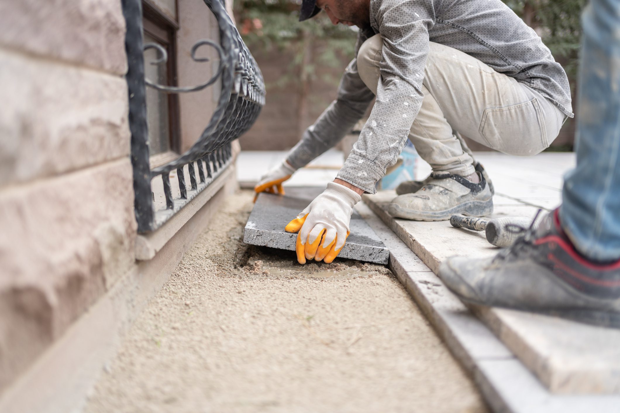 A Construction Worker İnstalling Stone On Floor